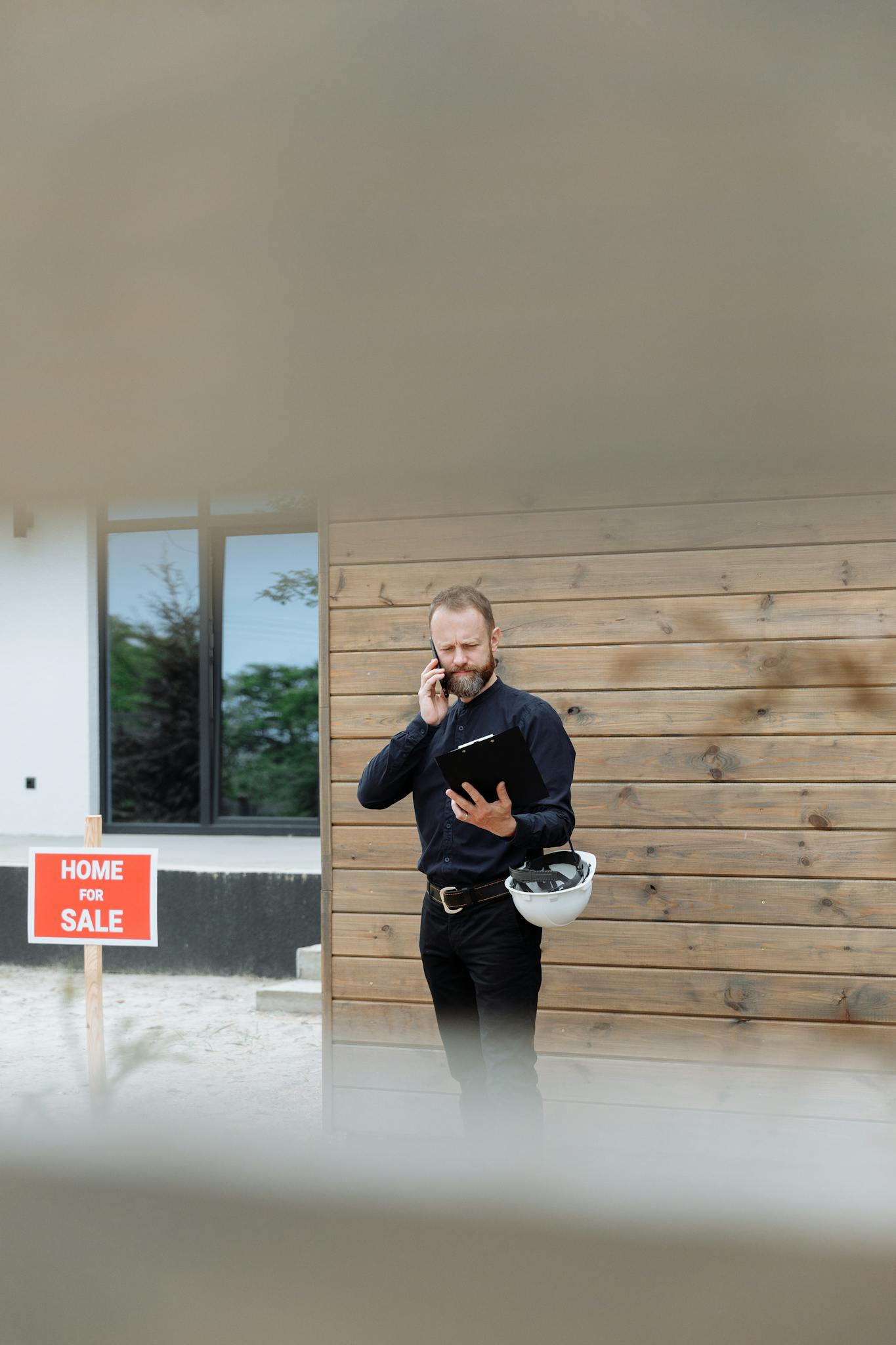 Real Estate Agent Holding Phone And Clipboard